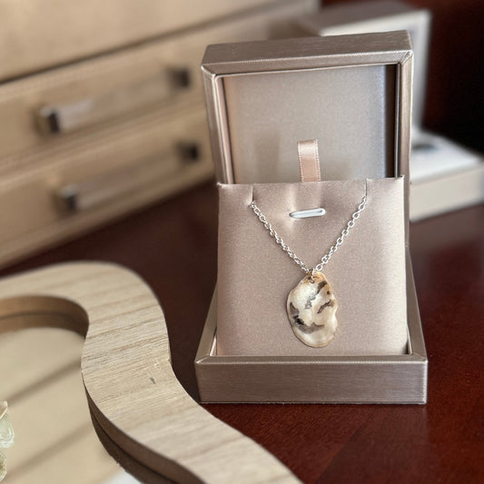 Necklace with pendant in a jewelry box on a wooden surface