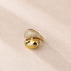 Gold ring with diamond accents on a beige background