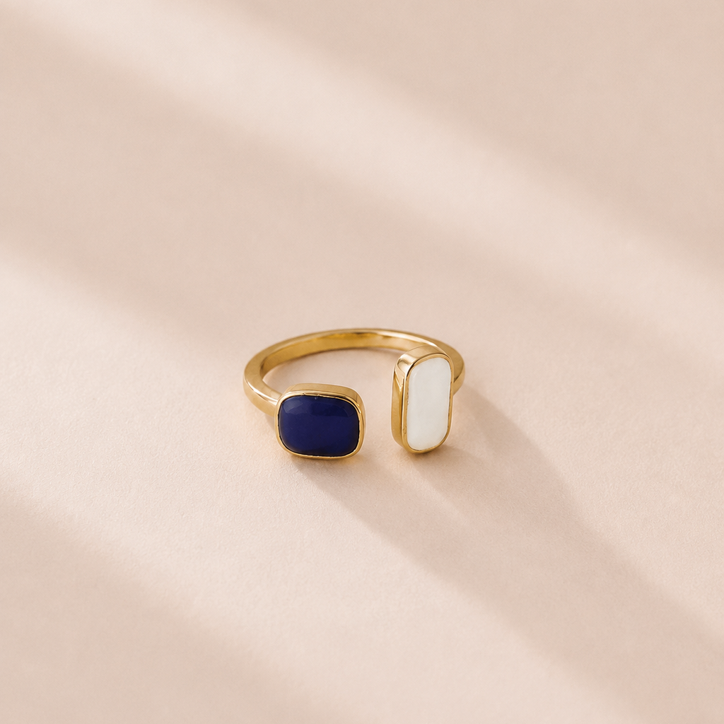 Gold ring with a blue stone on a beige background
