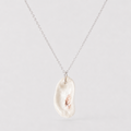 Necklace with a large, irregularly shaped pearl pendant on a light gray background