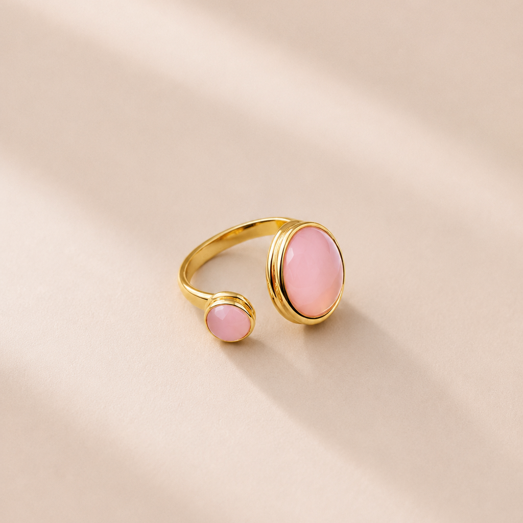 Gold ring with pink stones on a beige background
