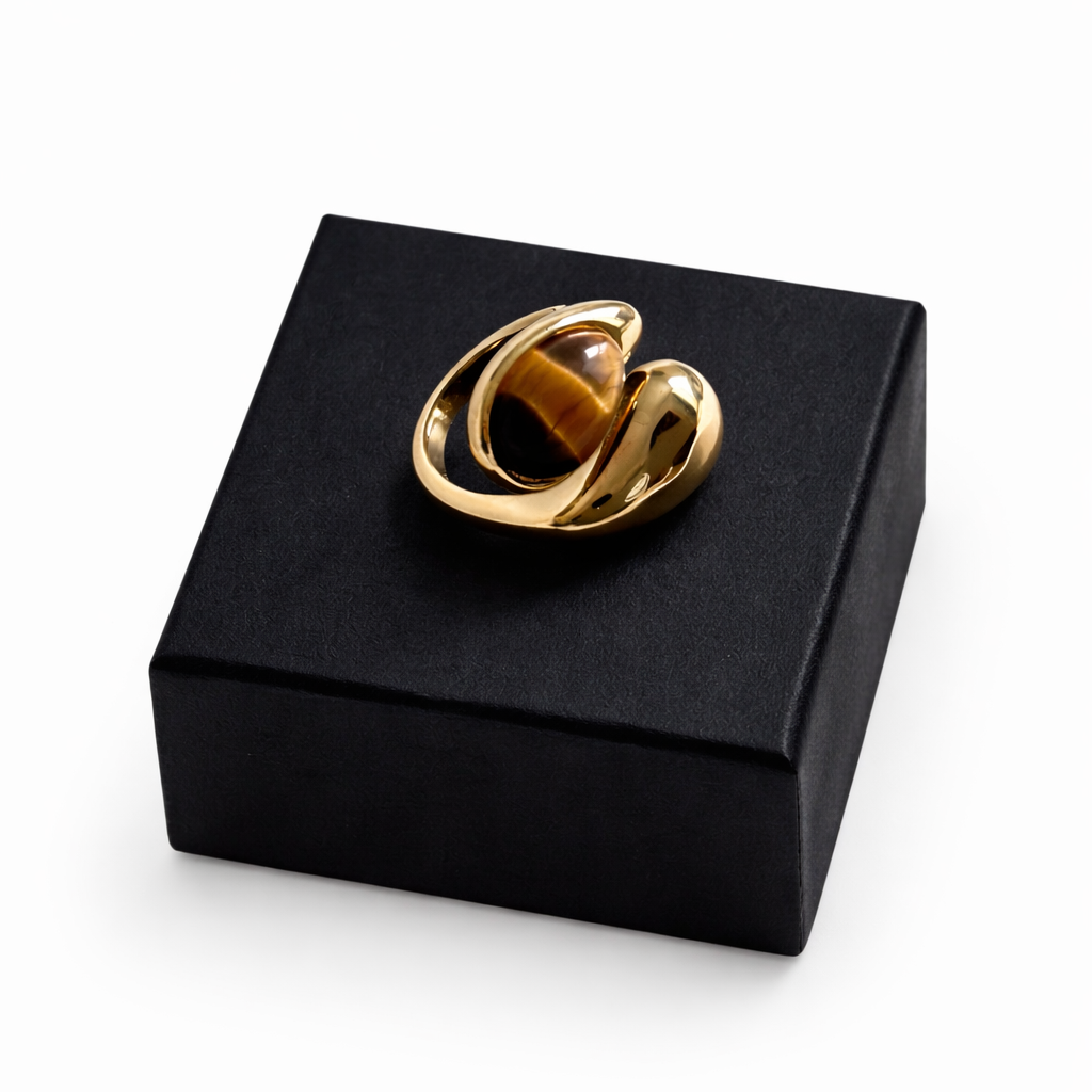 Gold ring on a black jewelry box against a white background