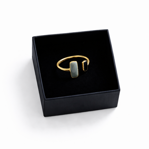 Gold ring with a stone in a black jewelry box on a white background