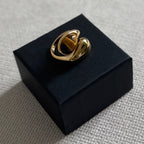 Gold ring on a black box against a gray background