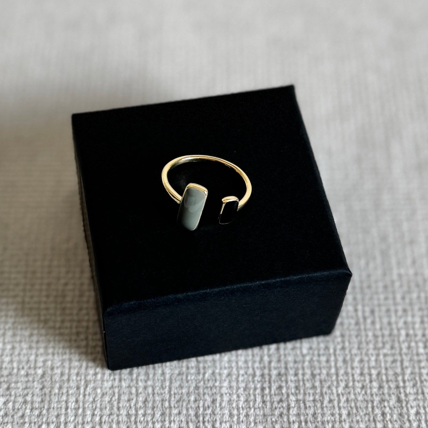 Gold ring on a black box with a gray background