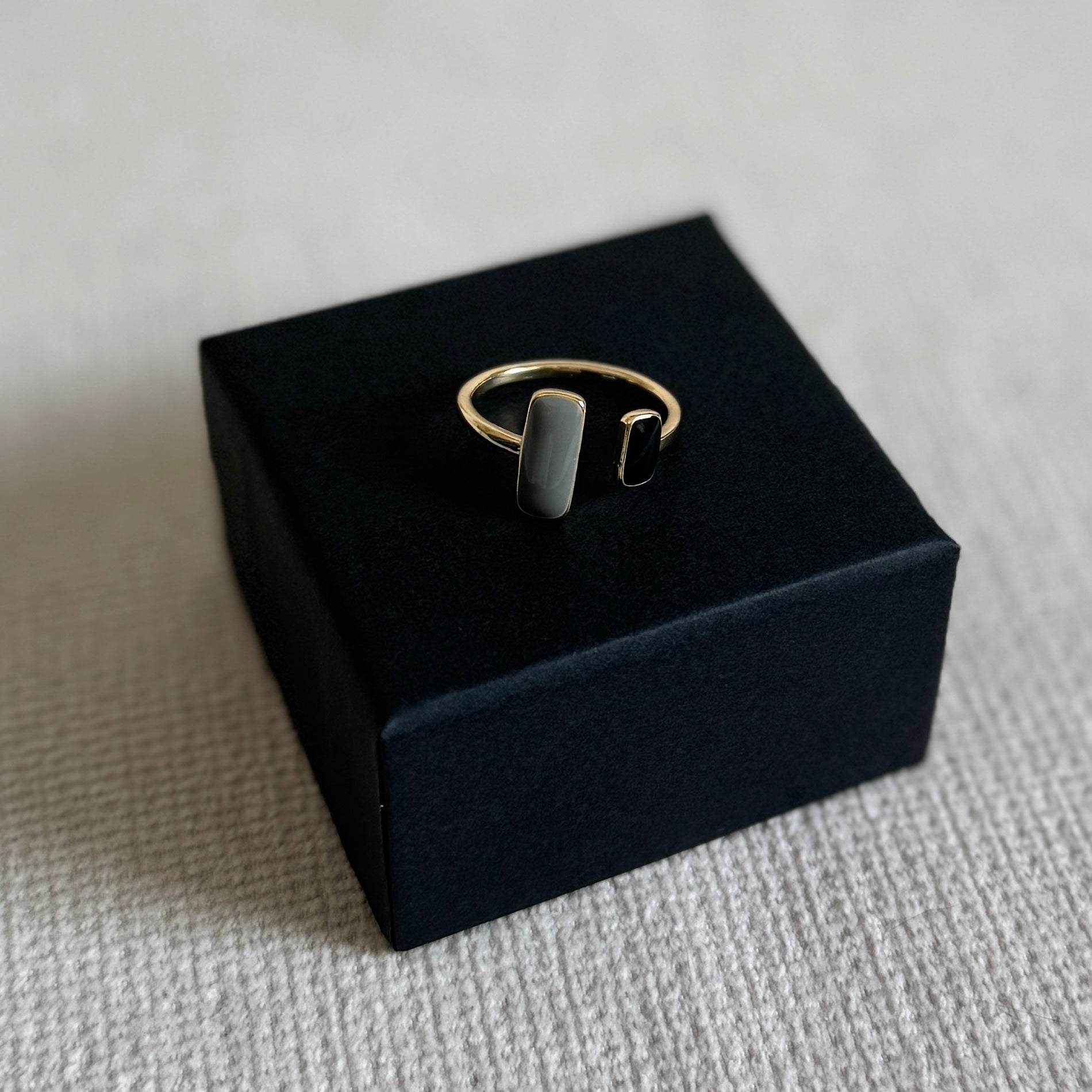 Gold ring on a black jewelry box with a light gray background