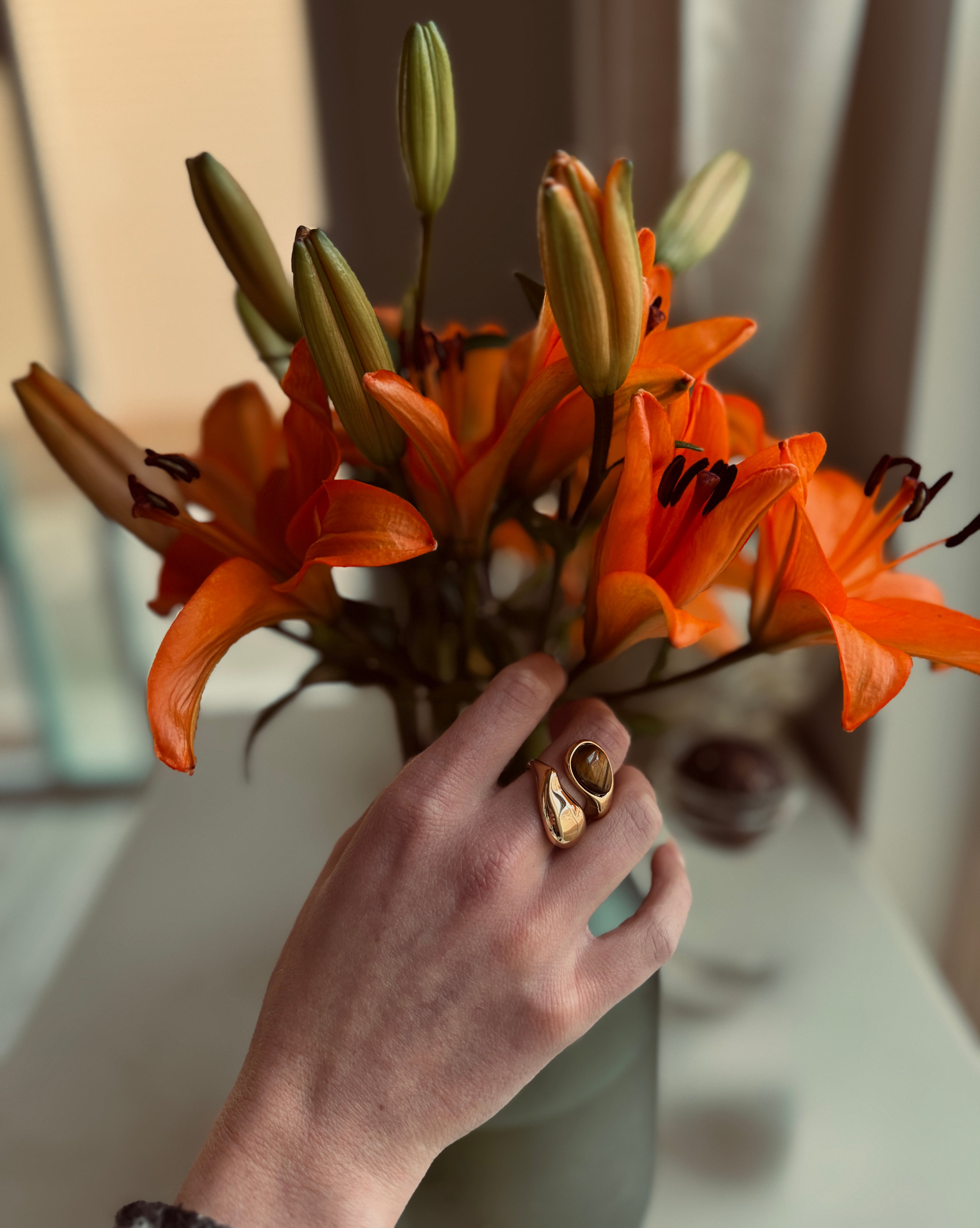 Hand holding a bouquet of orange flowers with a blurred background