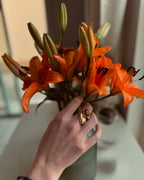Hand holding a bouquet of orange flowers with a blurred background