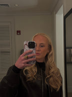 Person taking a mirror selfie wearing a black leather jacket.
