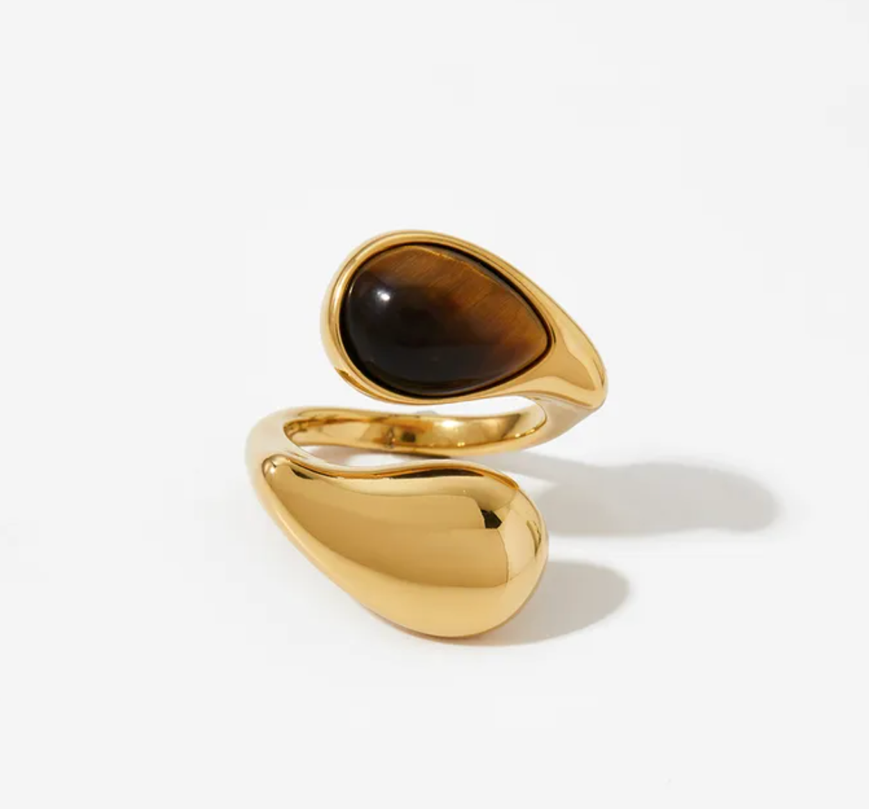 Gold ring with a brown stone on a white background