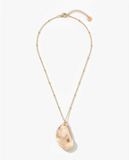 A gold chain necklace featuring a large, organic-shaped peach-colored stone pendant, displayed on a clean white background.