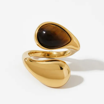 Gold ring with a brown gemstone on a white background